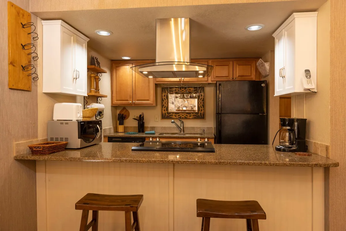 A welcoming kitchen with a large island and bar stools, modern appliances, and a decorative mirror. The space is styled for both cooking and entertaining, with an atmosphere that encourages socializing and casual gatherings.